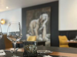 un tavolo con due bicchieri di vino bianco sopra di Logis Hotel Darcy Dijon Centre a Digione