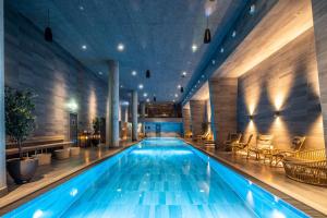 a swimming pool in a hotel with chairs and tables at Scandic Spectrum in Copenhagen