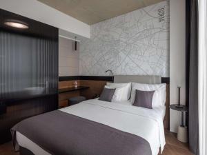 a bedroom with a large white bed and a map on the wall at Mövenpick Zagreb in Zagreb