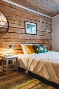 1 dormitorio con 1 cama y pared de madera en Boutique Hotel Marta 8, en Tallin