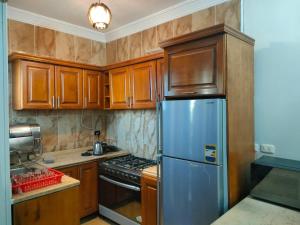 a kitchen with wooden cabinets and a stainless steel refrigerator at Blue Bay Asia Ain Elsokhna in Ain Sokhna