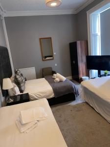 a hotel room with two beds and a mirror at Ellwyn House in Edinburgh
