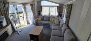 a living room with a couch and a table at NEW Mikey Caravan in Meliden