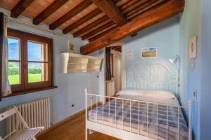 ein Schlafzimmer mit einem weißen Bett in einem Zimmer mit Holzdecken in der Unterkunft Casale San Rufino D'Arce in Assisi