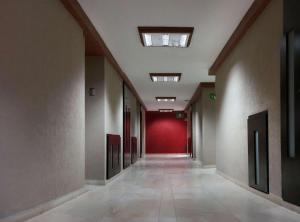 an empty hallway in a building with a red wall at Sleep Inn Puebla Centro Historico in Puebla