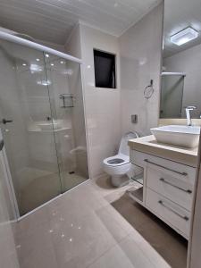 a bathroom with a shower and a toilet and a sink at Apto com sacada in Balneário Camboriú