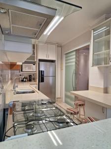a kitchen with a stove and a counter top at Apto com sacada in Balneário Camboriú