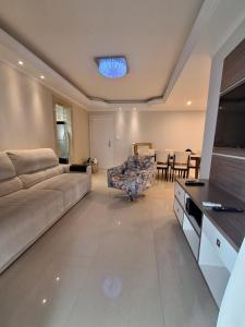 a living room with a couch and a dining room at Apto com sacada in Balneário Camboriú