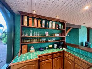 a kitchen with a green tiled counter and shelves at Greenland 15pers jacuzzi sauna airhockey billard in Hudimesnil +20 photos