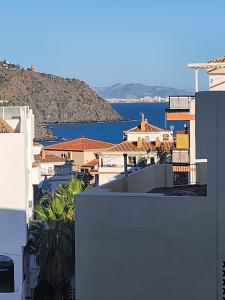 Blick auf eine Stadt mit Häusern und Wasser in der Unterkunft Bonito apartamento tesorillo in Almuñécar