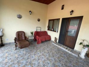 een woonkamer met een stoel en een deur bij Pensiunea Mihaita in Tîrgu Ocna