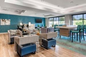 克拉克斯維爾的住宿－Comfort Inn & Suites，大堂设有带椅子和桌子的等候区