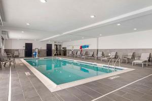una piscina en un hotel con sillas y mesas en Comfort Inn & Suites, en Clarksville