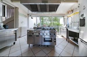 uma grande cozinha com um fogão e uma grande janela em Maison sur l'eau avec jardin et piscine em Bellerive-sur-Allier