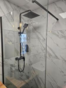 a shower with a glass door in a bathroom at Apartament Malta in Poznań
