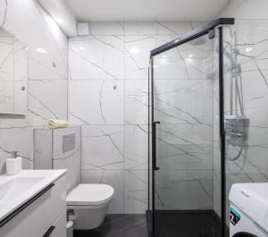 a white bathroom with a shower and a toilet at Downtown Deluxe in Omiš