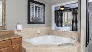 een badkamer met een bad en een grote spiegel bij 2 Bd Grand Desert Resort resort in Las Vegas