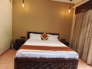 um quarto com uma cama grande e 2 almofadas em Yogu's Woodside em Sabari