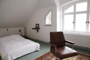 1 dormitorio con 1 cama y 1 silla en Grüne Villa, en Bad Brambach