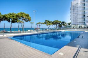 a swimming pool with the ocean in the background at Penthouse on the first line in Platja d'Aro