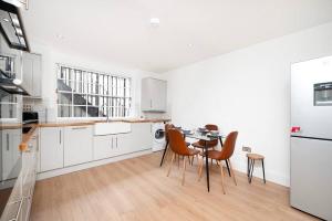 ロンドンにあるEuston/Fitzrovia - Brand new 2 bed, 5* SuperHostの白いキッチン(テーブル、椅子付)