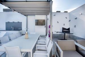a room with white furniture and a table and chairs at Penthouse on the first line in Platja d'Aro