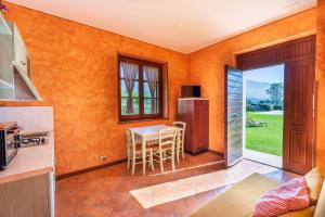 eine Küche mit orangefarbenen Wänden und einem Tisch mit Stühlen in der Unterkunft Casale San Rufino D'Arce in Assisi