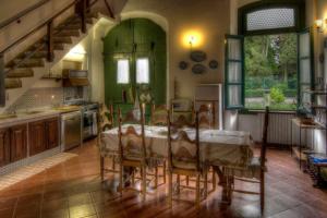 eine Küche mit einem Tisch mit Stühlen und einer Treppe in der Unterkunft Villa Luciano in Lastra a Signa