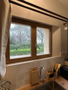 a kitchen sink with a window above a kitchen counter at 1560- Domaine Des Cinq Jardins- A Magical and Authentic Mansion in Fuveau