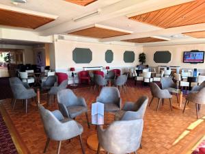 un restaurant avec des chaises et des tables ainsi qu'un bar dans l'établissement The Norfolk Lodge Hotel, à Saint-Hélier