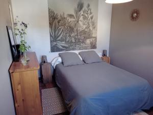 ein Schlafzimmer mit einem Bett und einem Wandgemälde in der Unterkunft Le 28 in Uzerche