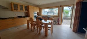 eine Küche mit einem Tisch und Stühlen sowie eine Küche mit einem Fenster in der Unterkunft Vivenda do Parque Arouca in Arouca