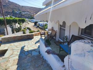 a porch of a house with a swing at Omisu Apartments in Kithnos