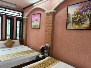 a room with two beds and a painting on the wall at Quynh Moon homestay in Hanoi