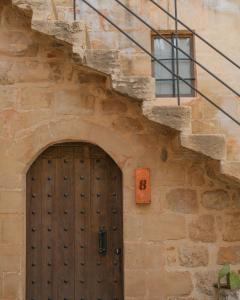 a stone building with a wooden door and stairs at Mirsoum Han in Mardin