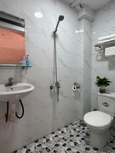 a white bathroom with a sink and a toilet at Quynh Moon homestay in Hanoi
