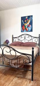 een bed in een slaapkamer met een schilderij aan de muur bij Maison d'une chambre avec jardin amenage et wifi a Saint Germain in Saint-Germain