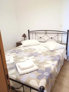 una camera da letto con un grande letto con asciugamani di Ballas seaview apartment a Perdika