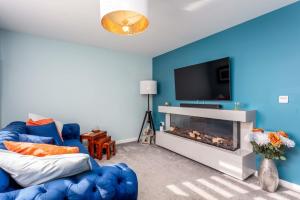 a blue living room with a couch and a fireplace at 29 Ancestors Field in Prestwick
