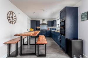 a kitchen with blue cabinets and a wooden table at 29 Ancestors Field in Prestwick