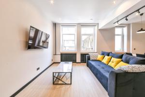 a living room with a blue couch and a tv at Apartments near Ozas in Vilnius