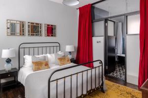 a bedroom with a large bed with red curtains at Magic Moments - London Bridge - by Frankie Says in London