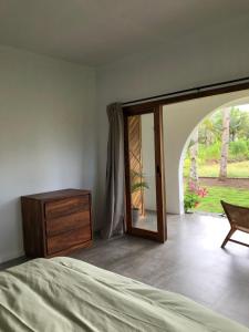 バツカラスにあるRumah Markisa Batukarasのベッドルーム1室(ベッド1台、ドレッサー、窓付)