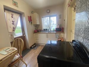 a kitchen with a sink and a stove top oven at Cosy Rural Cottage Peak District, Pets Welcome in Hollinsclough
