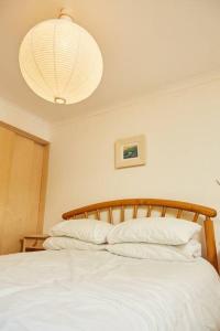 een slaapkamer met een wit bed en een kroonluchter bij Premium Central Stroud Apartment with Parking x2 