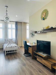 a living room with a large television and a desk at Kael Apartman 02 in Teplice