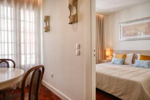 a bedroom with a bed and a table in a room at Colombo Square, a Home in Madeira in Funchal