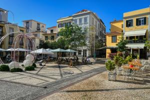 a town square with tables and chairs and buildings at Colombo Square, a Home in Madeira in Funchal