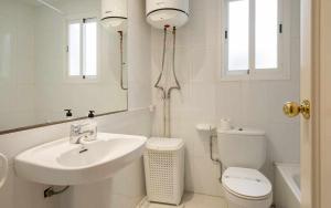 a bathroom with a sink and a toilet and a mirror at Nautic wifi Parking y a 150 metros de la playa in Tossa de Mar