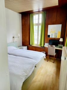 1 dormitorio con 1 cama y escritorio con ordenador en Nydeck en Berna